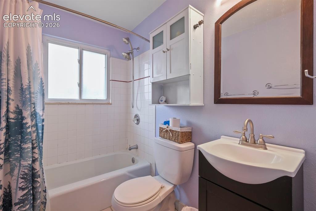 Image 15 of 26: Full bathroom featuring a window, white subway tile shower surround, shower