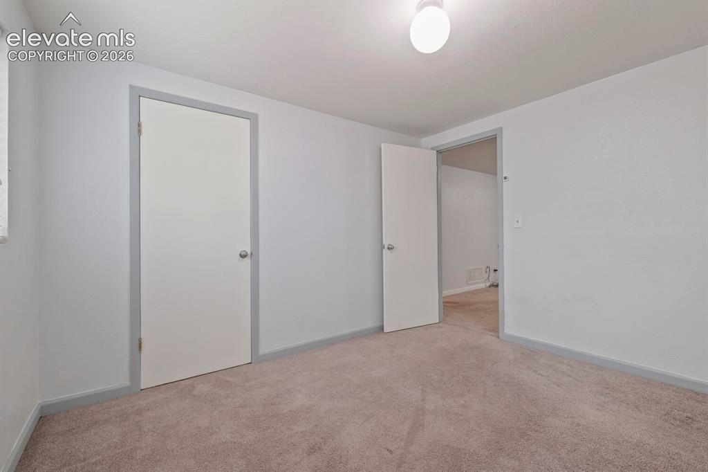Image 20 of 26: Carpeted interior space featuring light gray walls, white trim, and a flush