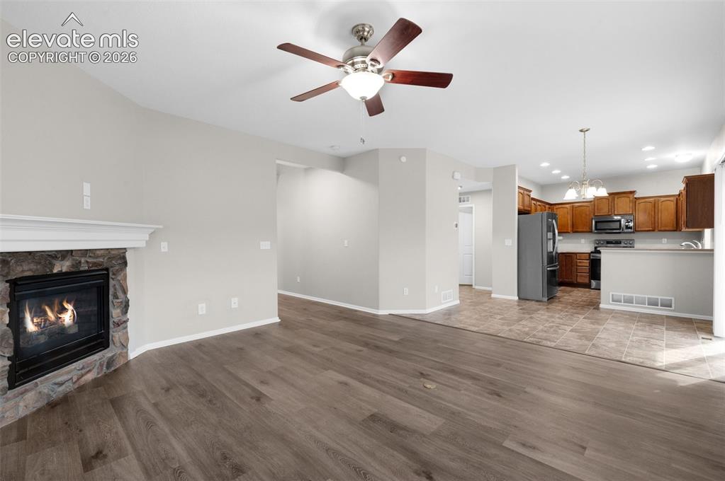 Image 21 of 41: Spacious living room with fireplace and an open connection to the kitchen a