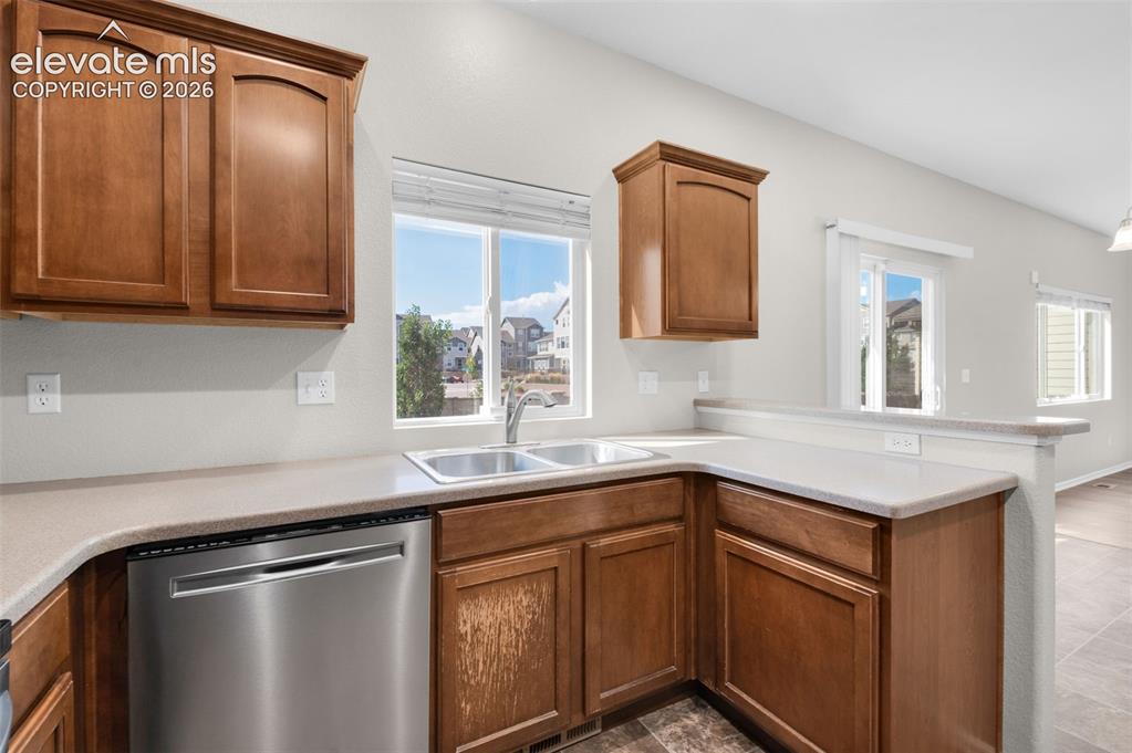 Image 23 of 41: Natural light over the kitchen workspace with additional cabinetry and coun