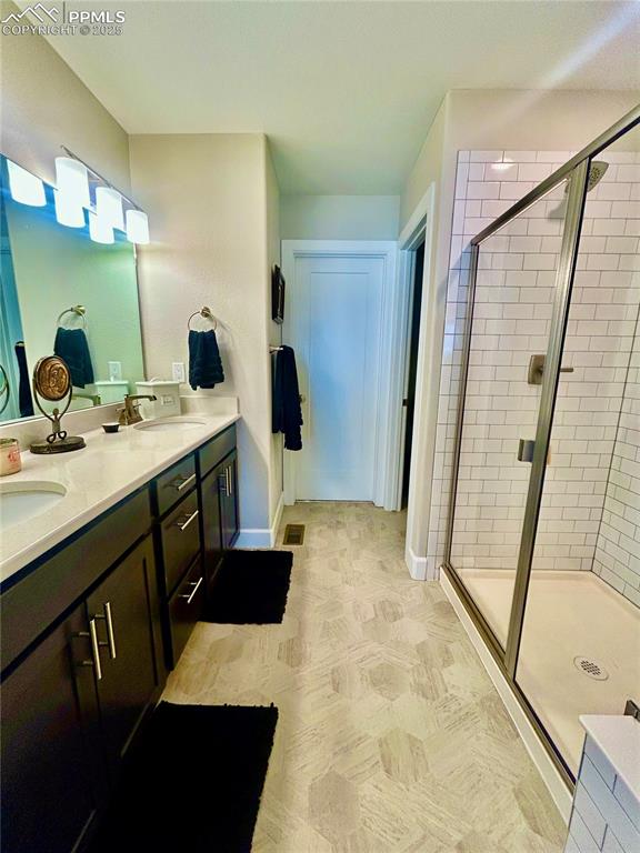 Image 17 of 30: The primary bathroom is large with a walk-in shower with a seat, and double