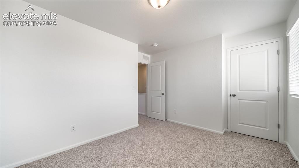 Image 3 of 24: Neutral wall paint, two panel interior doors, flush mount ceiling light, an