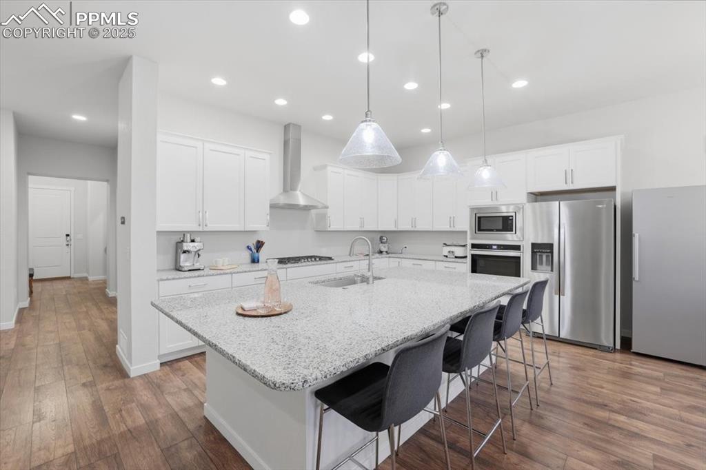 Image 10 of 43: Kitchen with stainless steel appliances, white cabinetry, dark wood-type fl
