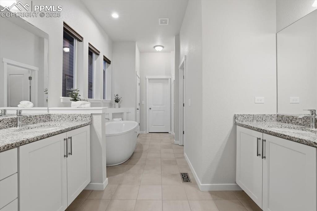 Image 18 of 43: Full bathroom with a soaking tub, two vanities, freestanding shower and wal