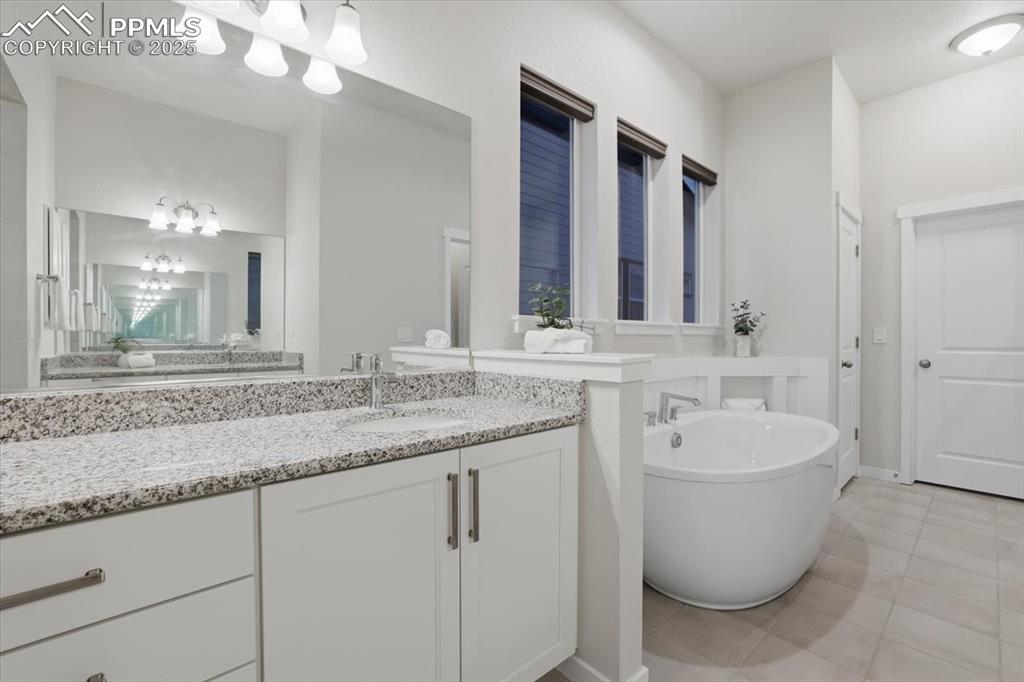 Image 21 of 43: Bathroom featuring a freestanding tub, light tile patterned floors, and van