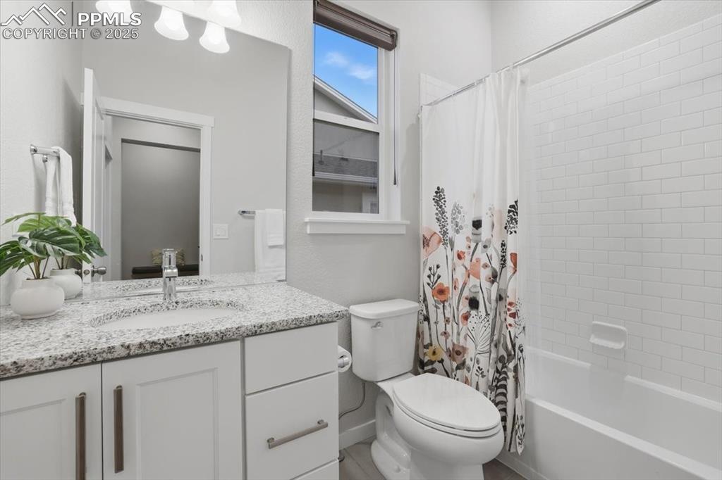 Image 27 of 43: Full bath with shower / bath combo with shower curtain and vanity