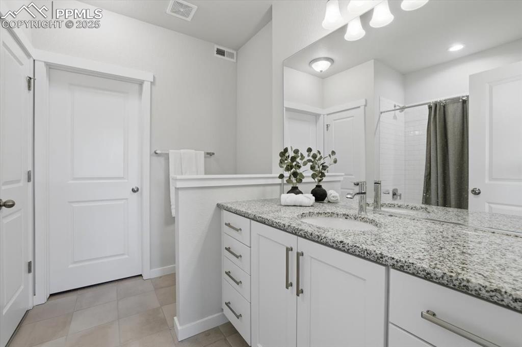 Image 30 of 43: Secondary en-suite full bath featuring vanity, a shower with shower curtain