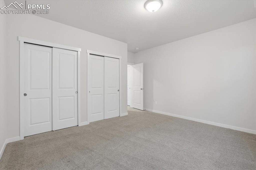Image 38 of 43: Unfurnished bedroom with two closets and light carpet