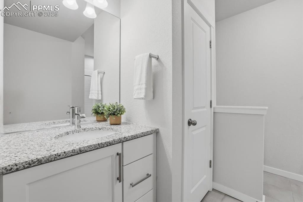 Image 39 of 43: Bathroom with vanity and light tile patterned flooring