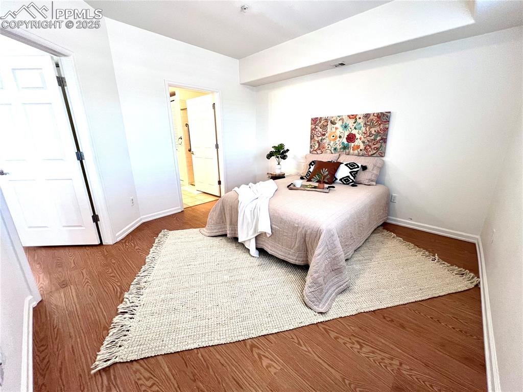 Image 11 of 30: Primary Bedroom featuring wood-type flooring and connected bathroom