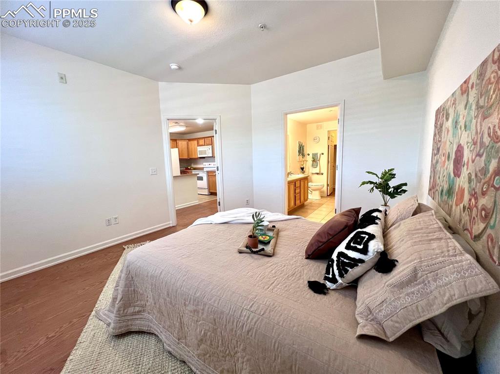 Image 14 of 30: Bedroom featuring connected bathroom, and hardwood / wood-style floors, ove
