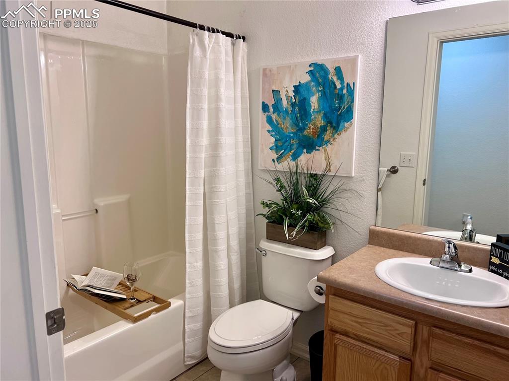 Image 21 of 30: Full bathroom with shower / bath combo with shower curtain, toilet, and van