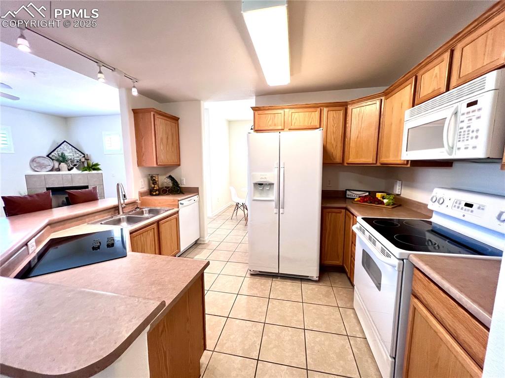 Image 7 of 30: Kitchen featuring white appliances, sink, kitchen peninsula