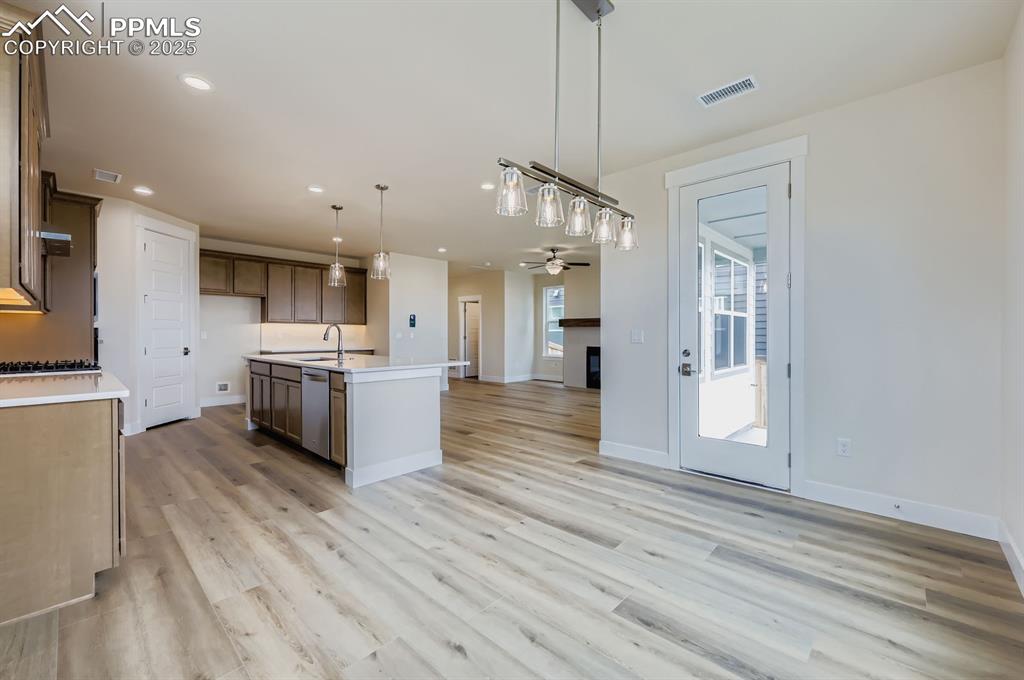 Image 10 of 28: Kitchen with open floor plan, light countertops, pendant lighting, ceiling 