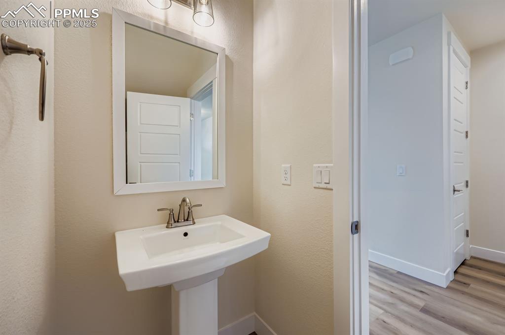 Image 11 of 28: Bathroom with wood finished floors and baseboards