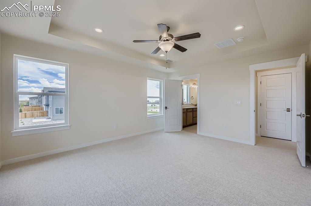 Image 13 of 28: Unfurnished bedroom featuring a raised ceiling, light carpet, recessed ligh