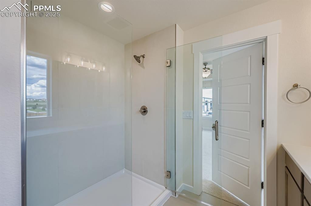 Image 16 of 28: Full bath with a shower stall, vanity, and healthy amount of natural light