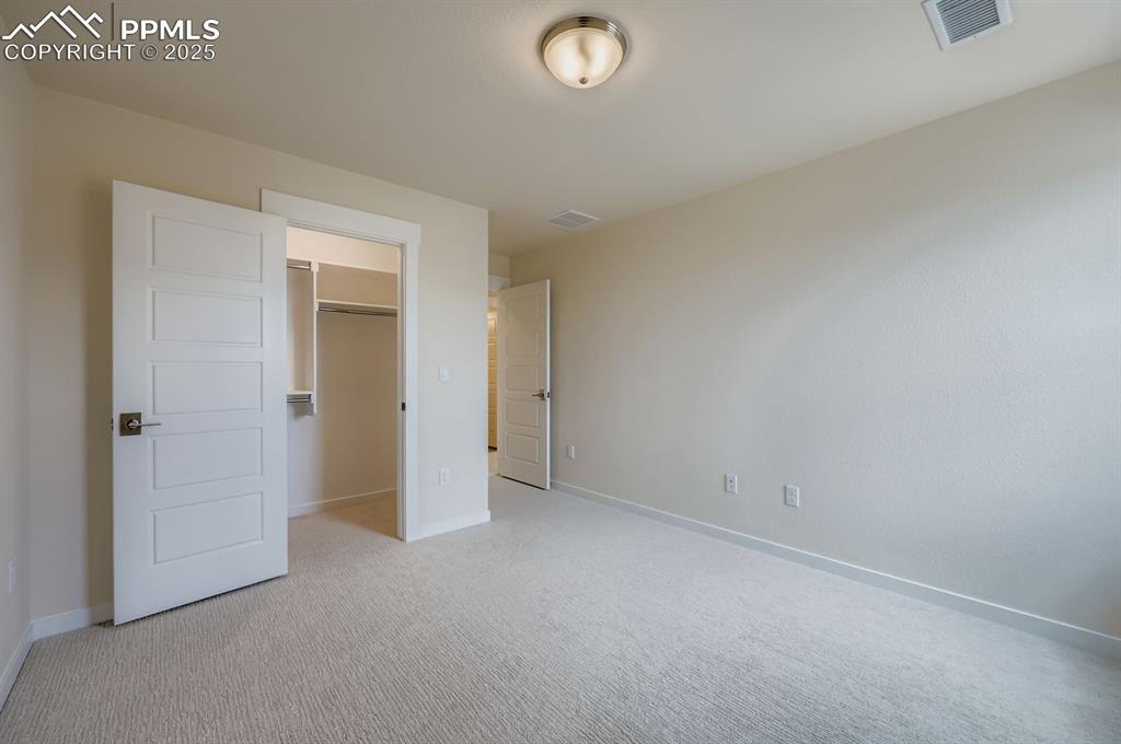 Image 19 of 28: Unfurnished bedroom featuring light colored carpet and a spacious closet