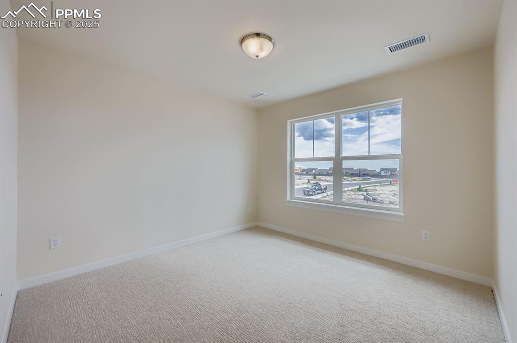 Image 20 of 28: Empty room featuring light colored carpet and a water view