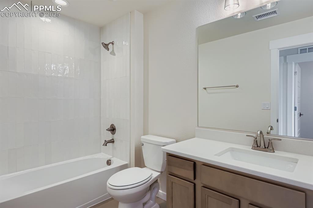 Image 22 of 28: Bathroom with vanity, bathtub / shower combination, and recessed lighting
