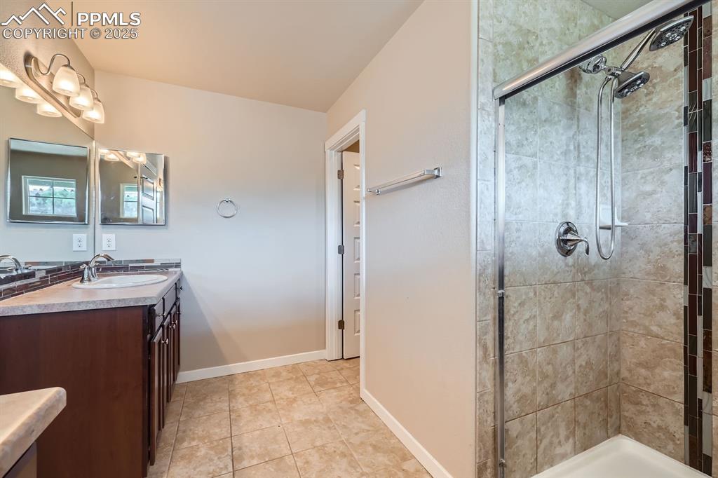 Image 16 of 27: Full bath with a shower stall, vanity, and tile patterned flooring