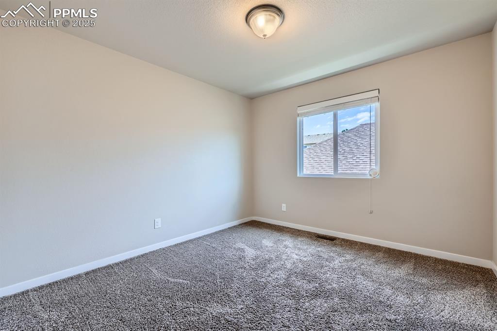 Image 19 of 27: Unfurnished room with carpet and baseboards