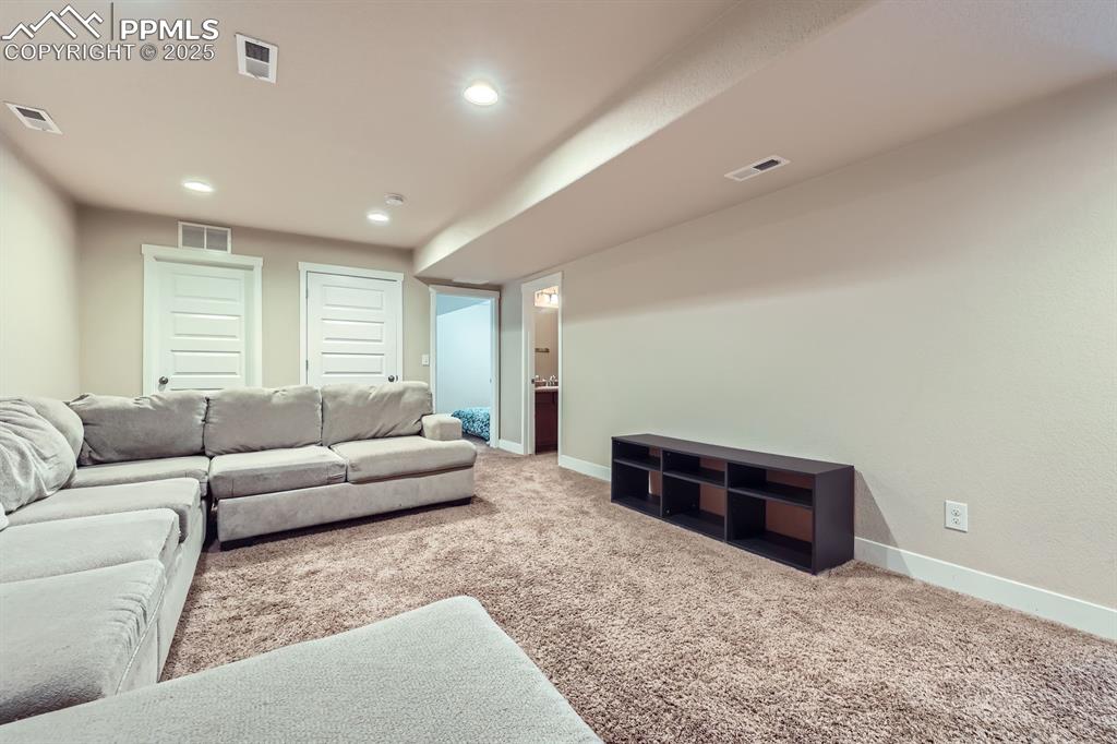 Image 24 of 27: Carpeted living area featuring baseboards and recessed lighting