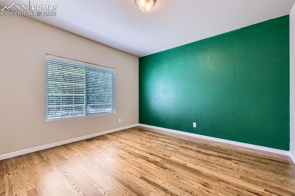 Image 6 of 27: Unfurnished room with wood finished floors and baseboards