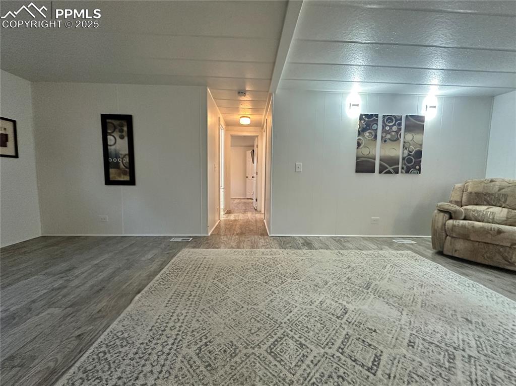 Image 21 of 36: Living area view into hall to secondary bedrooms.