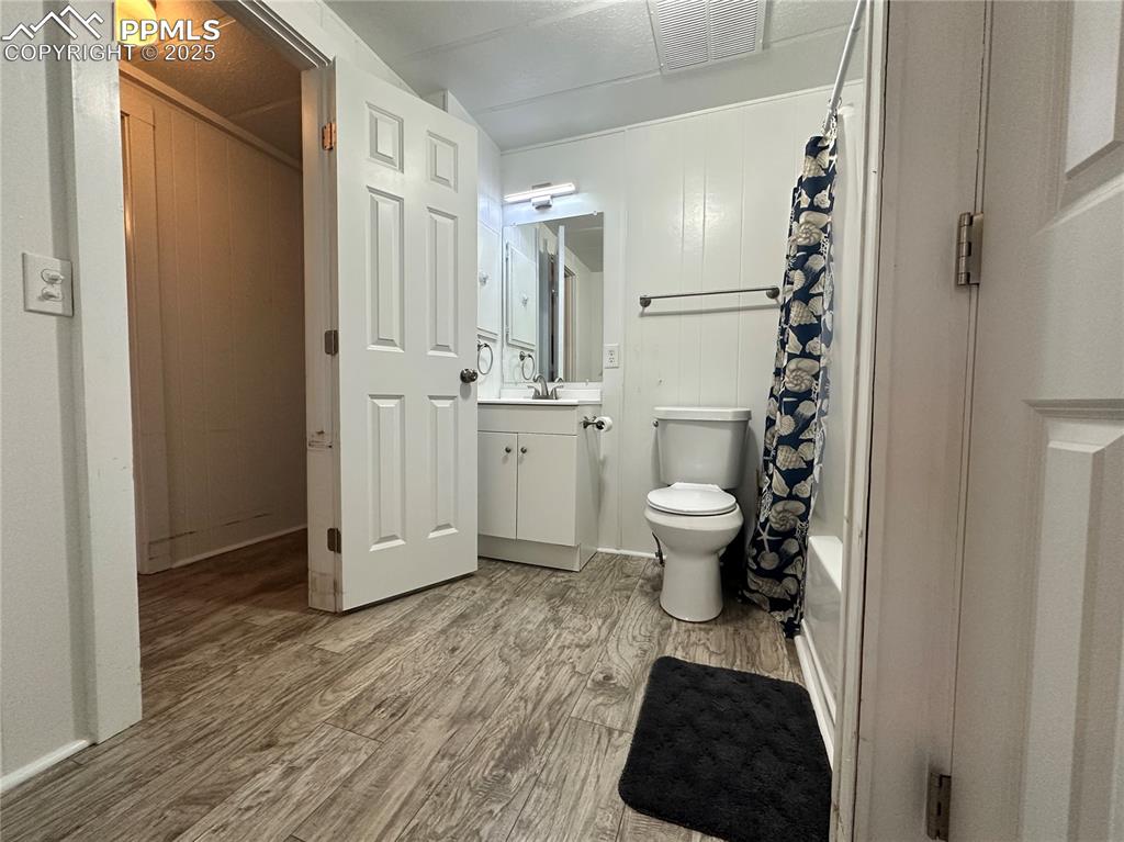 Image 26 of 36: Full bathroom with vanity, light wood-style floors, shower / bath combo, an