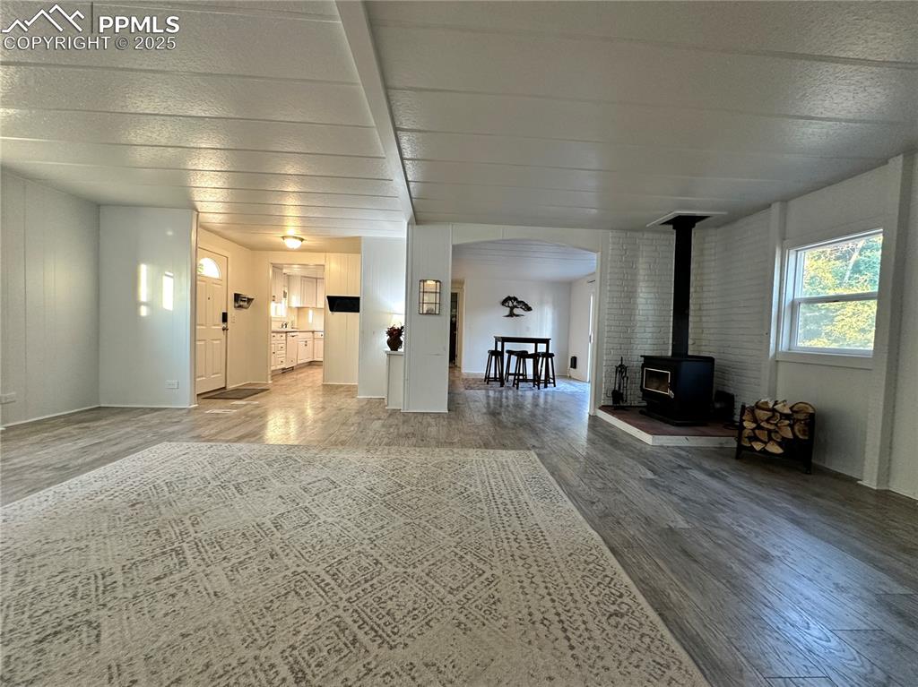 Image 29 of 36: Living area with a wood stove and wood finished floors