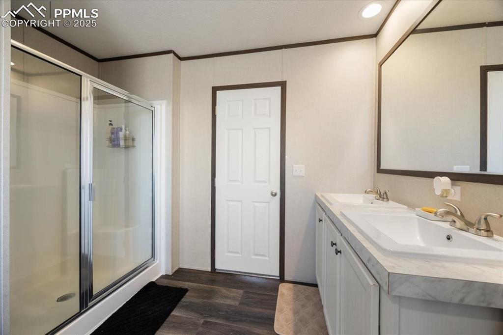 Image 11 of 40: Full bath with ornamental molding, a stall shower, dark wood-style floors, 