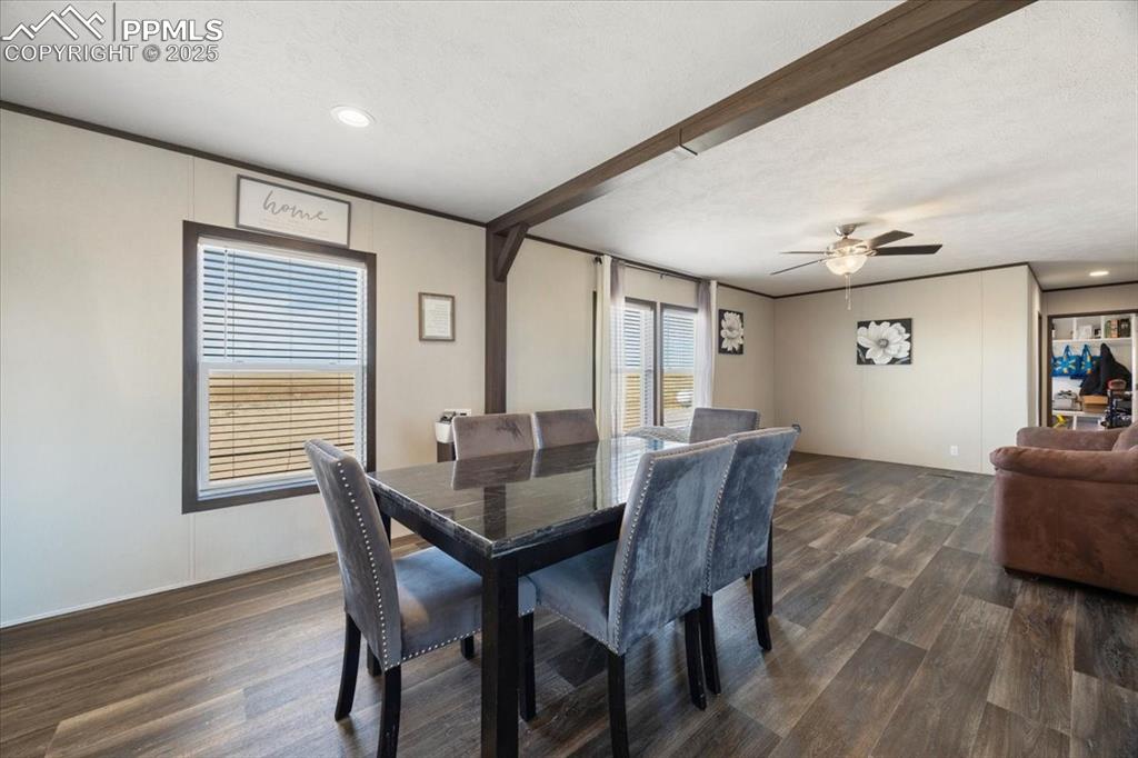 Image 15 of 40: Dining space with dark wood-style flooring, recessed lighting, beamed ceili