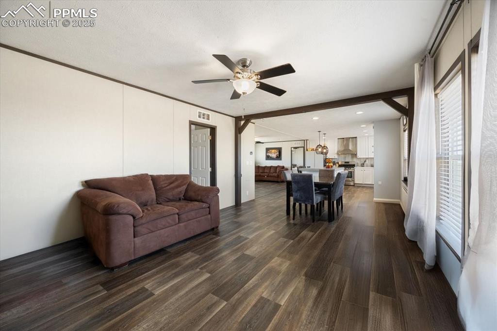 Image 20 of 40: Living room with dark wood-type flooring and ceiling fan