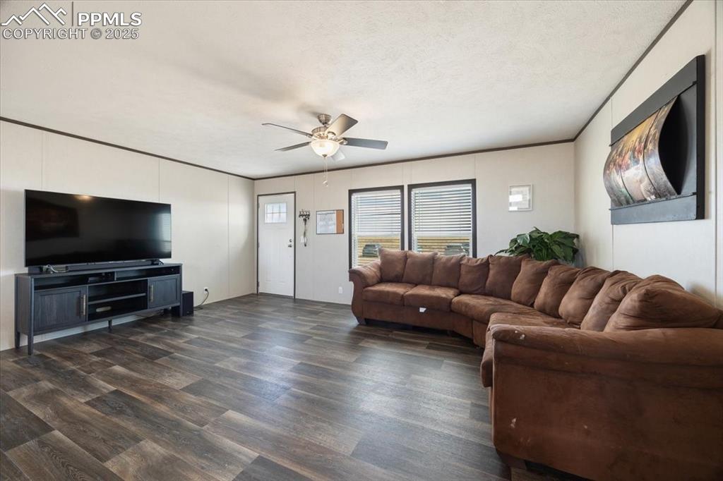 Image 5 of 40: Living room featuring dark wood finished floors, a textured ceiling, a ceil