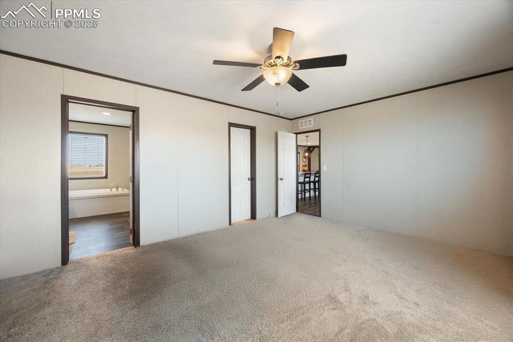 Image 8 of 40: Unfurnished bedroom featuring ornamental molding, carpet flooring, a ceilin