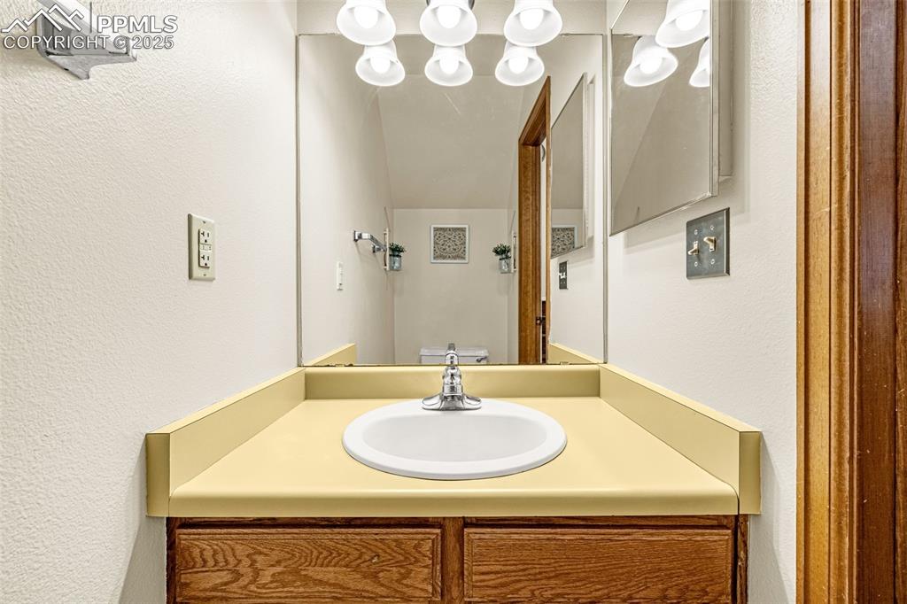 Image 16 of 37: Bathroom with a textured wall and vanity