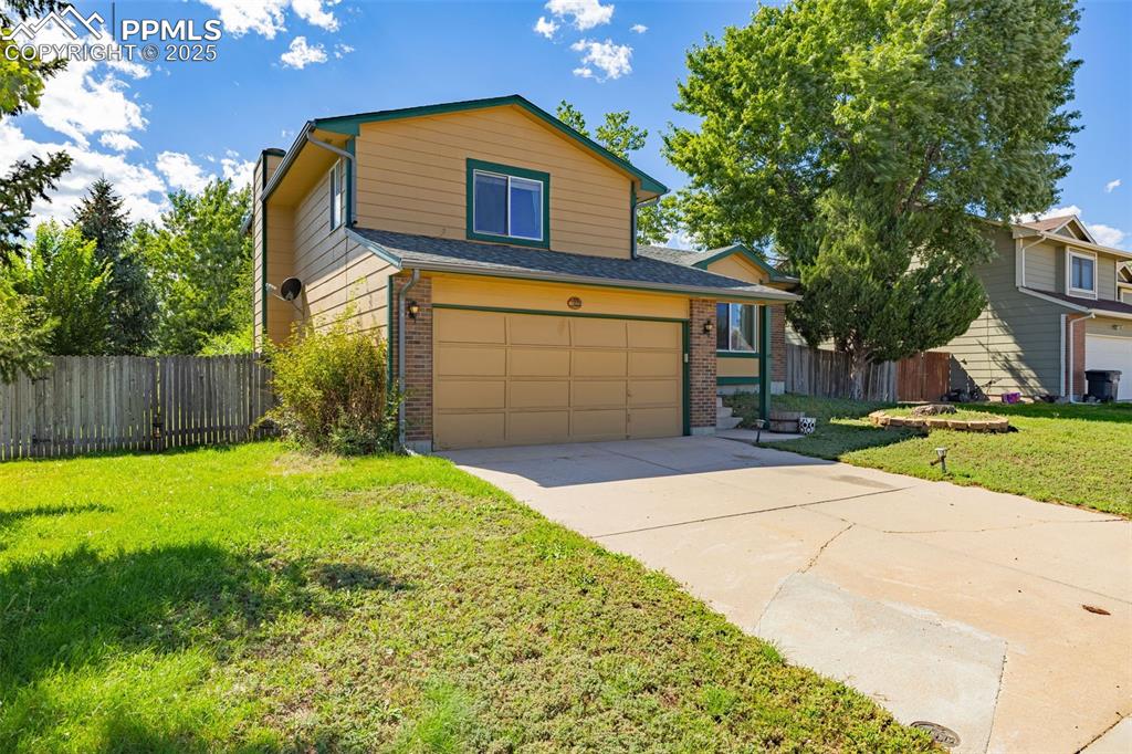 Image 2 of 37: View of front of house with brick siding, an attached garage, concrete driv