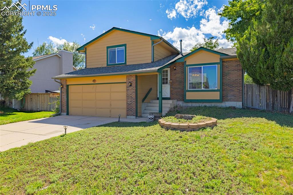 Image 3 of 37: View of front facade featuring brick siding, an attached garage, concrete d
