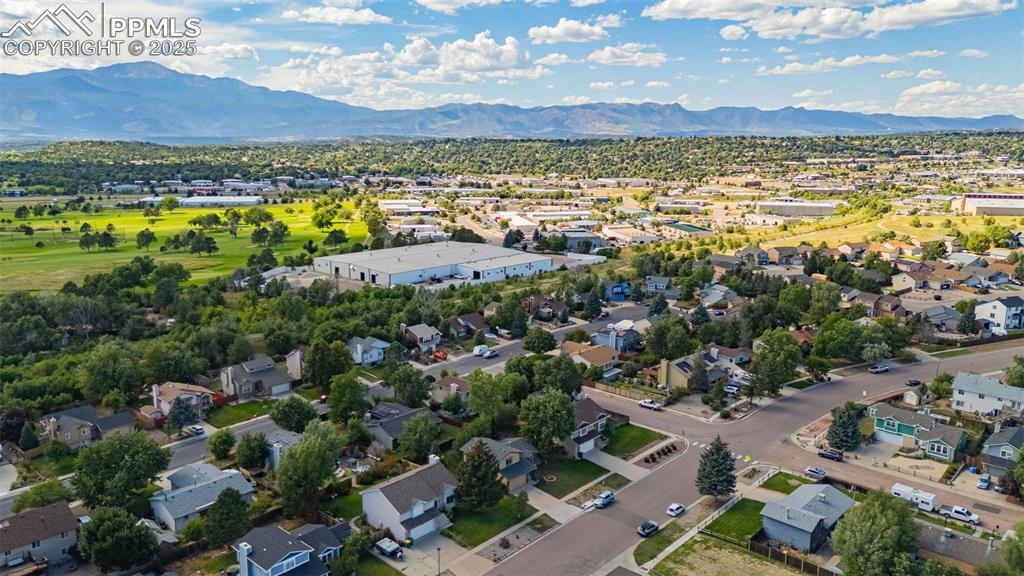 Image 33 of 37: Aerial view of residential area featuring a mountainous background