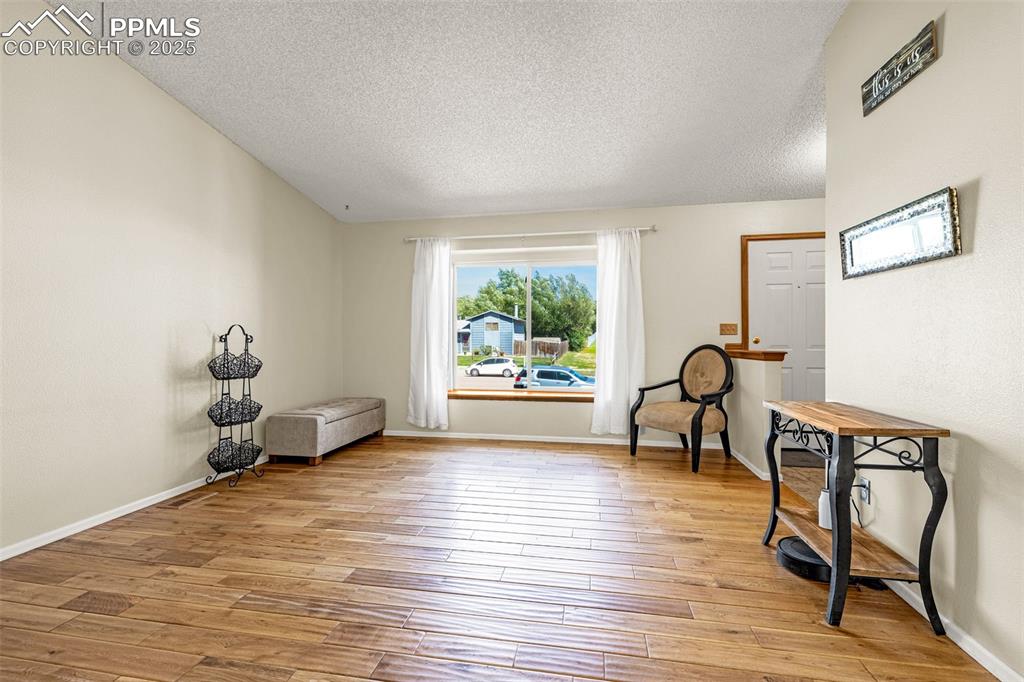 Image 6 of 37: Sitting room featuring a textured ceiling and light wood-type flooring