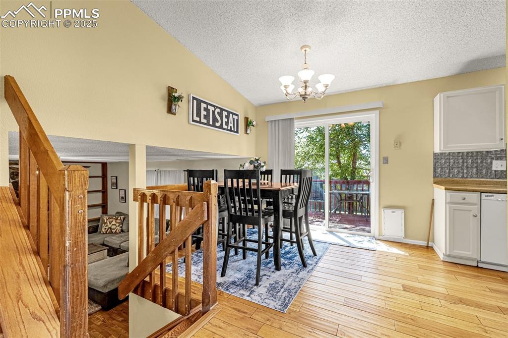 Image 8 of 37: Dining space with a textured ceiling, light wood finished floors, a chandel