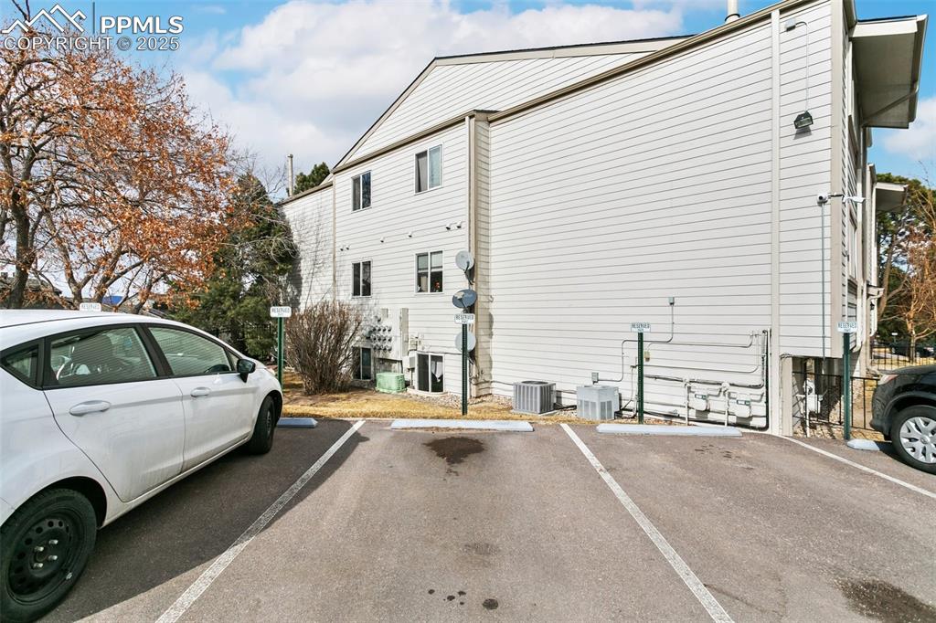 Image 28 of 30: View of side of property with uncovered parking and cooling unit