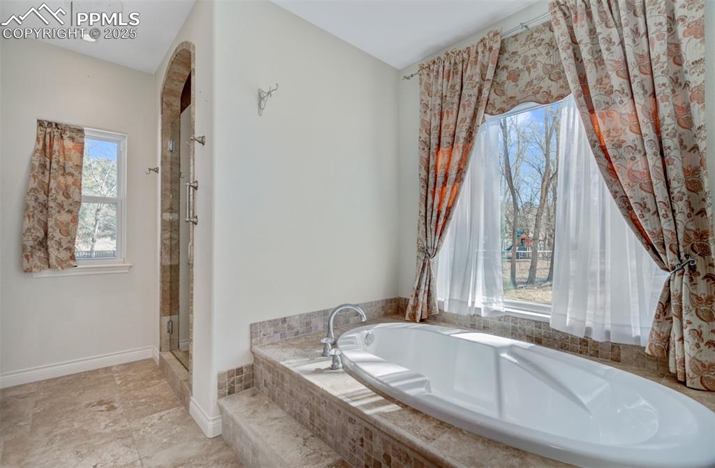 Image 13 of 48: Primary 5 piece bathroom with tile flooring and a walk in closet
