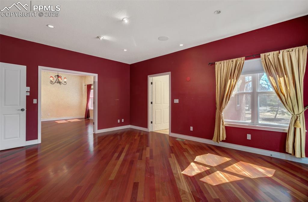 Image 8 of 48: Primary bedroom with wood flooring, an en suite 5 piece bathroom and a walk