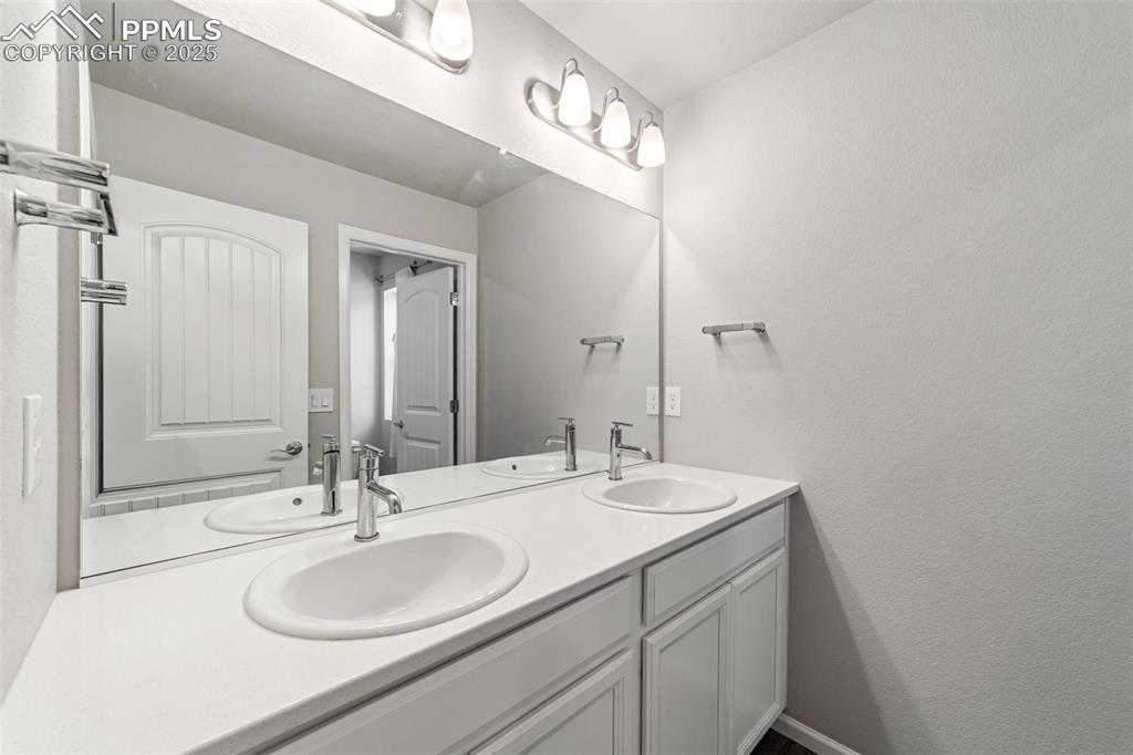 Image 17 of 23: Full upper-level bath with modern vanity and updated lighting.