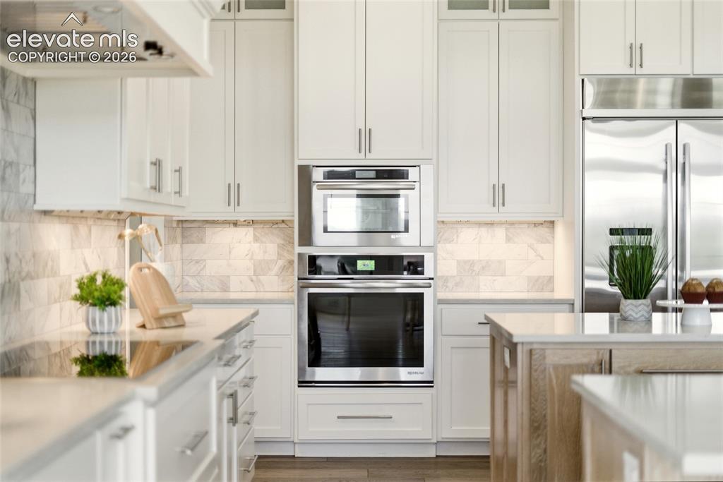 Image 11 of 50: Gourmet kitchen featuring stainless steel appliances, built-in double ovens