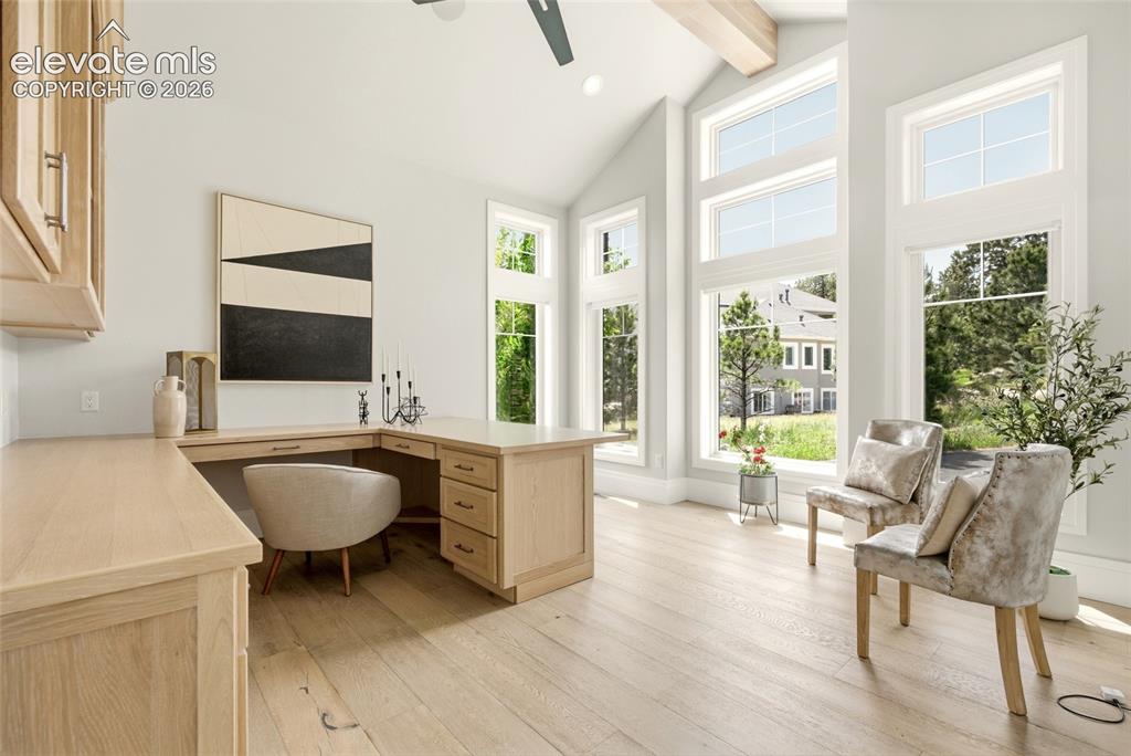 Image 14 of 50: Bright room featuring a vaulted ceiling with an exposed beam, light wood-fi