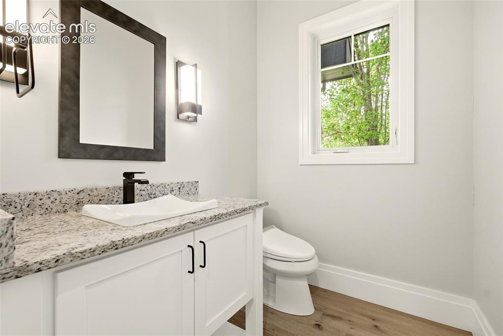 Image 17 of 50: Bathroom featuring a white vanity with shaker-style cabinetry, a speckled c
