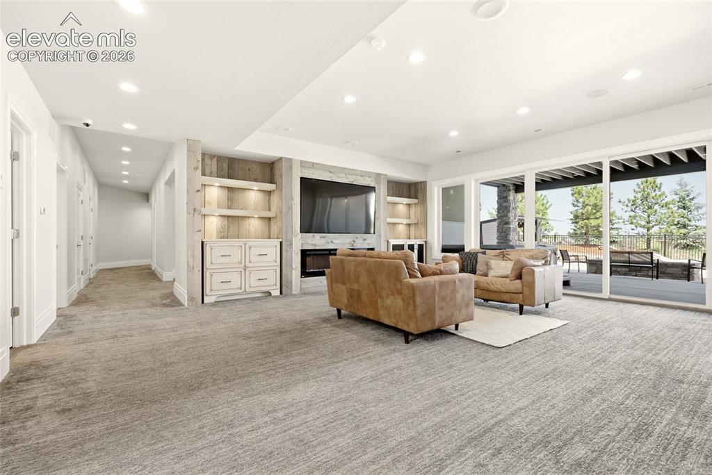 Image 26 of 50: Entertainment space featuring neutral-toned carpeting and a built-in media